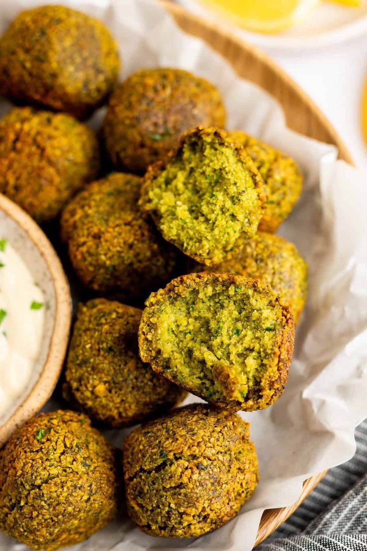 a basket filled with broccoli bites next to a small bowl of ranch dressing