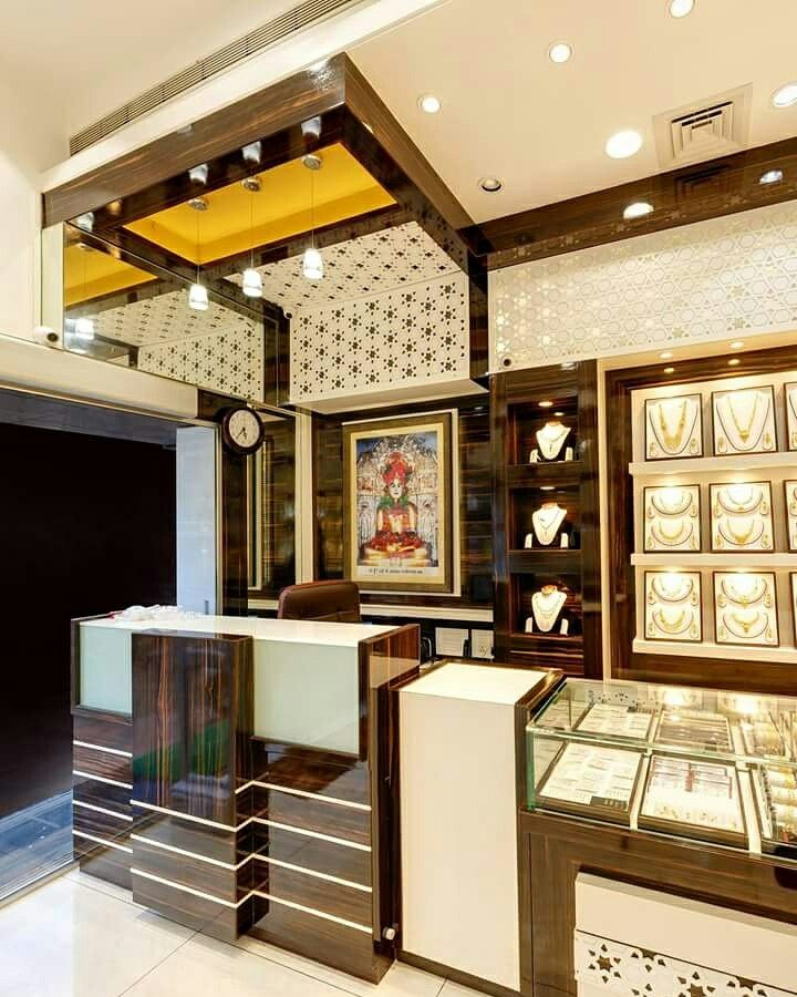 a store with glass cases and paintings on the walls, including an ornately decorated wall