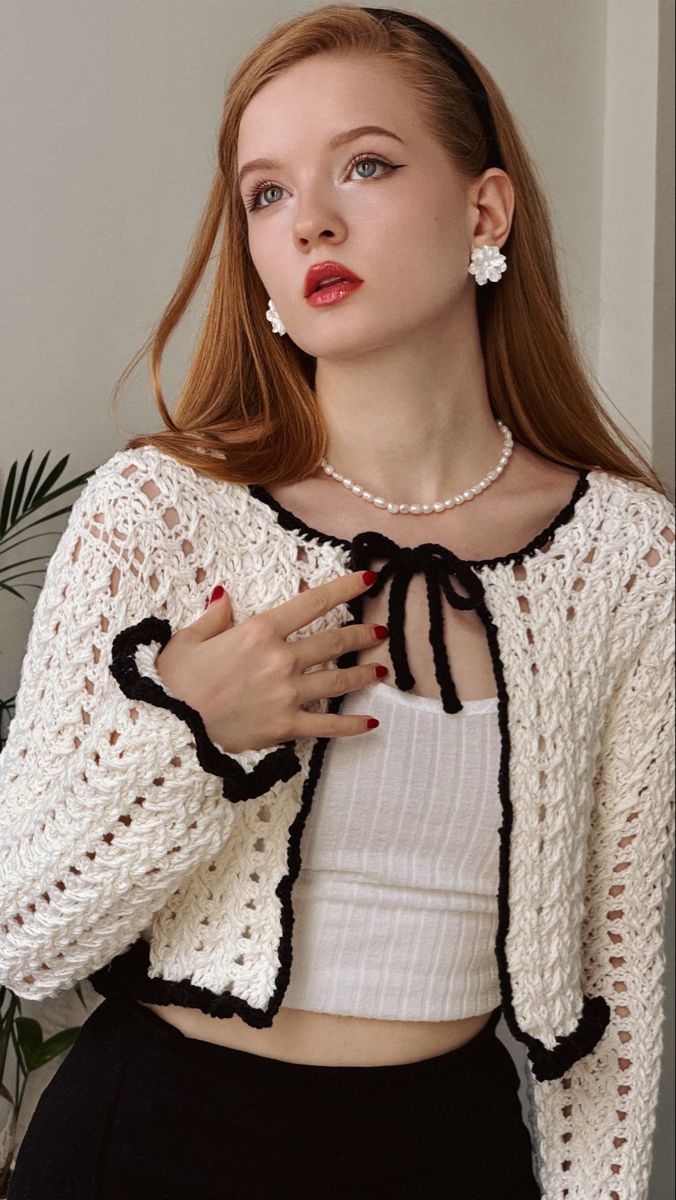 a woman with long hair wearing a white top and black skirt is posing for the camera