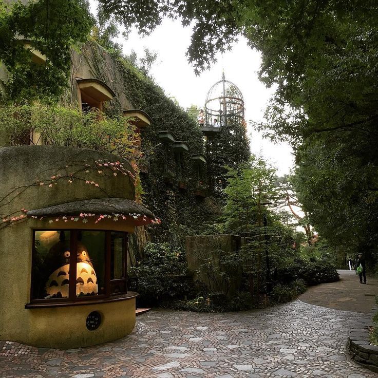 an unusual looking house with plants growing on the roof