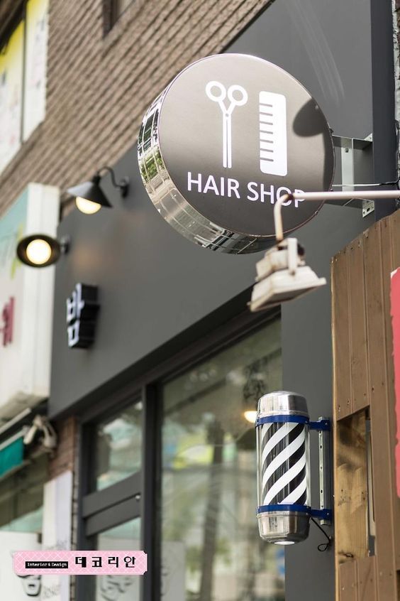 a hair shop sign hanging from the side of a building