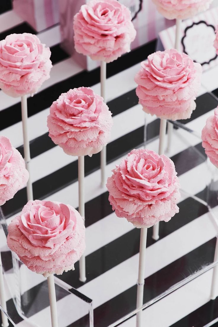 pink flowers on sticks with black and white striped background