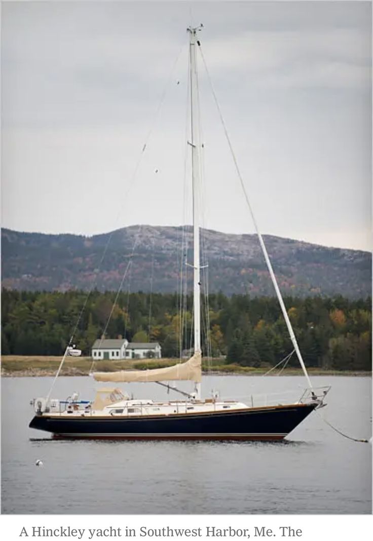 a sailboat in the water with mountains in the background