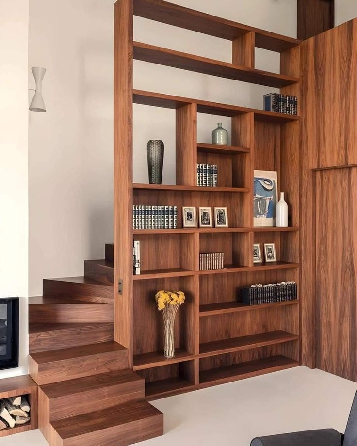 a living room filled with lots of wooden bookshelves next to a fire place