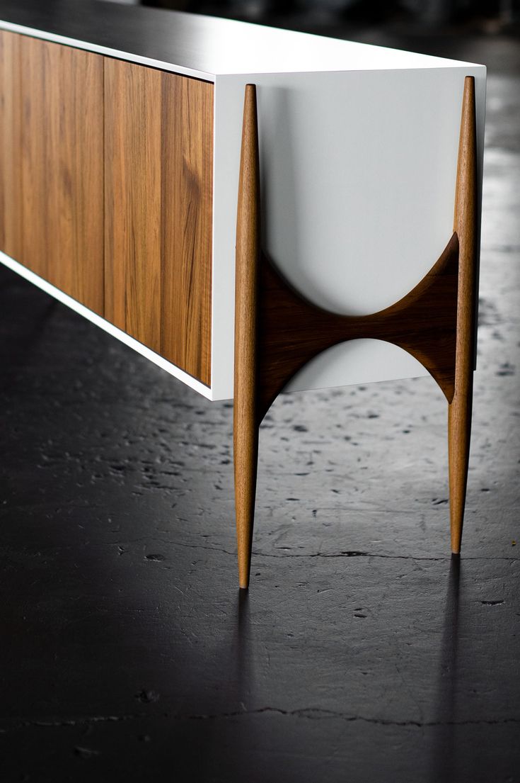 an unusual wooden and white sideboard on a black surface with dark wood trim around the edges