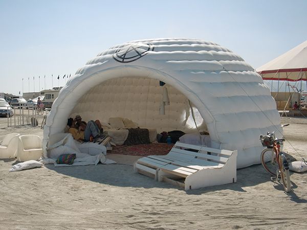 an inflatable tent is set up on the beach for people to sit and relax