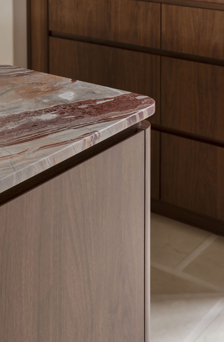 a marble counter top in a kitchen with wooden cabinets