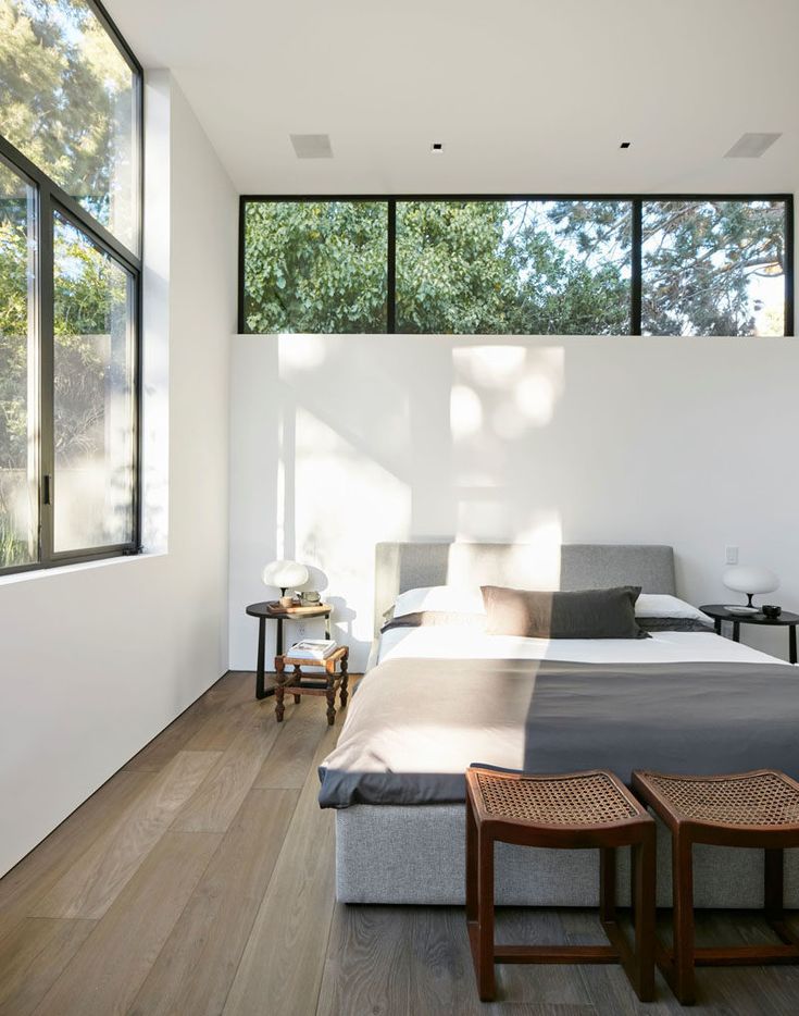 a bed sitting in the middle of a bedroom next to two tables