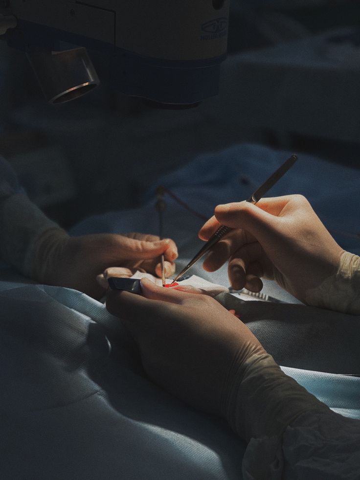 someone is doing something with scissors in their hand while another person sits on the bed