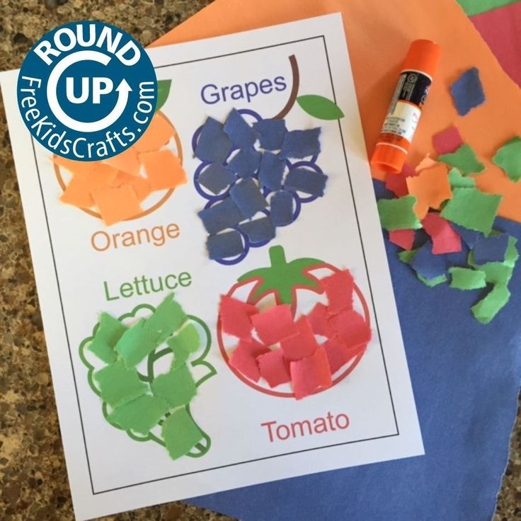 an orange, grape, lettuce and tomato cut out on top of paper