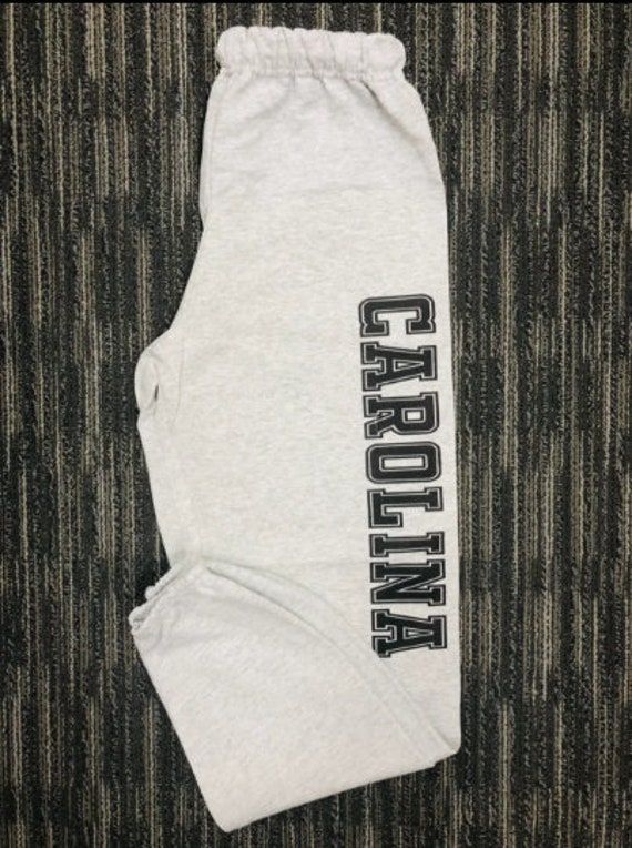 College Sweatpants Personalized | College Apparel | College Apparel Custom College name printed down left leg. Print Size 16x3in. 1 color Unisex Sweatpants - 973MR 8 oz., pre-shrunk 50/50 cotton/polyester Oxford is 49/51 cotton/polyester NuBlend pill-resistant fleece High stitch density for a smooth printing canvas No side seams Double-needle stitched covered waistband with inside drawcord Elastic bottom leg openings Casual Stretch Bottoms With Logo Print, Casual Cotton Pants With Logo Print, Sports Cotton Pants With Logo Print, Sporty Stretch Bottoms With Logo Print, Sports Cotton Pants With Letter Print, Stretch Cotton Pants With Letter Print, Casual Letter Print Bottoms For College, Casual Cotton Bottoms For College, Gray Letter Print Athleisure Pants