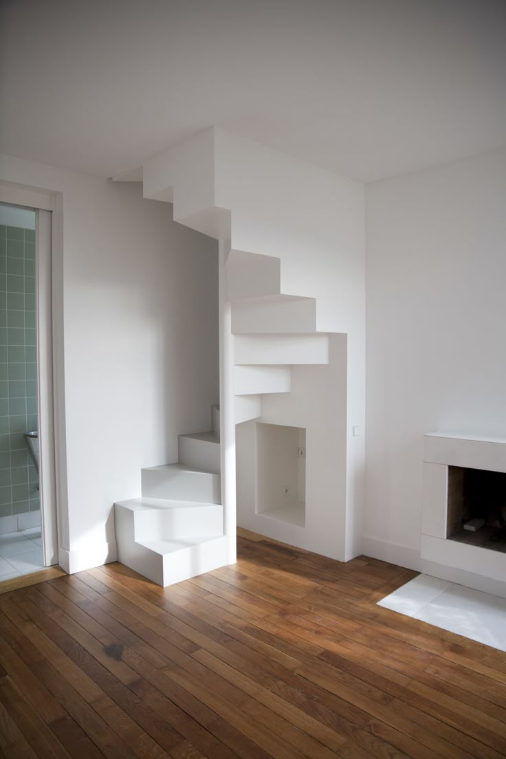 an empty room with white walls and wooden floors