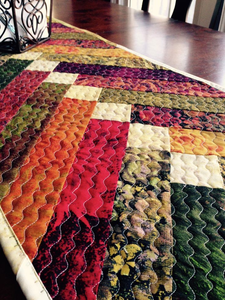 a quilted table runner on top of a dining room table