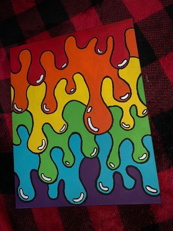 a colorful painting on a red and black checkered blanket