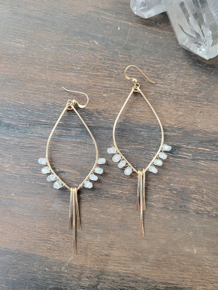 So in love with these Moonstone Tulip Earrings! These beauties are abstract art pieces of tulips that you can wear and take with you on your adventures! They are the perfect addition to your Spring/Summer jewelry and they go with just about anything! They are available in Sterling Silver and 14K Gold Filled. Each piece is hand formed and hammered for texture and shape. Four beautiful Moonstone Gems are wire wrapped up each side of the earring. The length of the earrings are just a tad over 3 in. Artisan Dangle Teardrop Earrings With Ear Wire, Artisan Teardrop Dangle Earrings With Ear Wire, Delicate Wire Wrapped Earrings For Everyday, Wire Wrapped Long Drop Earrings For Everyday, Everyday Wire Wrapped Long Drop Earrings, Everyday Long Drop Wire Wrapped Earrings, Wire Wrapped Moonstone Drop Earrings, Bohemian Teardrop Crystal Earrings For Pierced Ears, Bohemian Teardrop Crystal Earrings