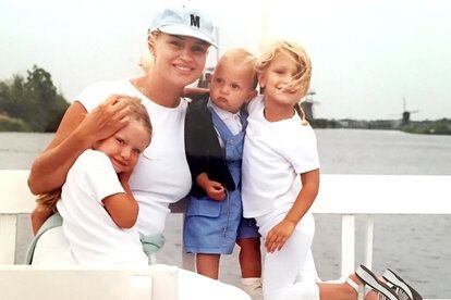 a man and two children on a boat posing for a picture with their arms around each other