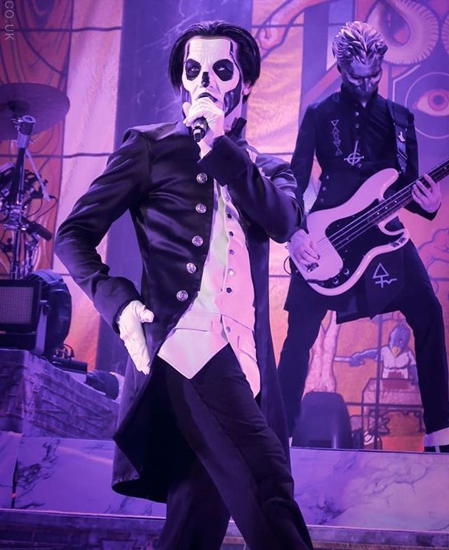 a man dressed in black and white is performing on stage