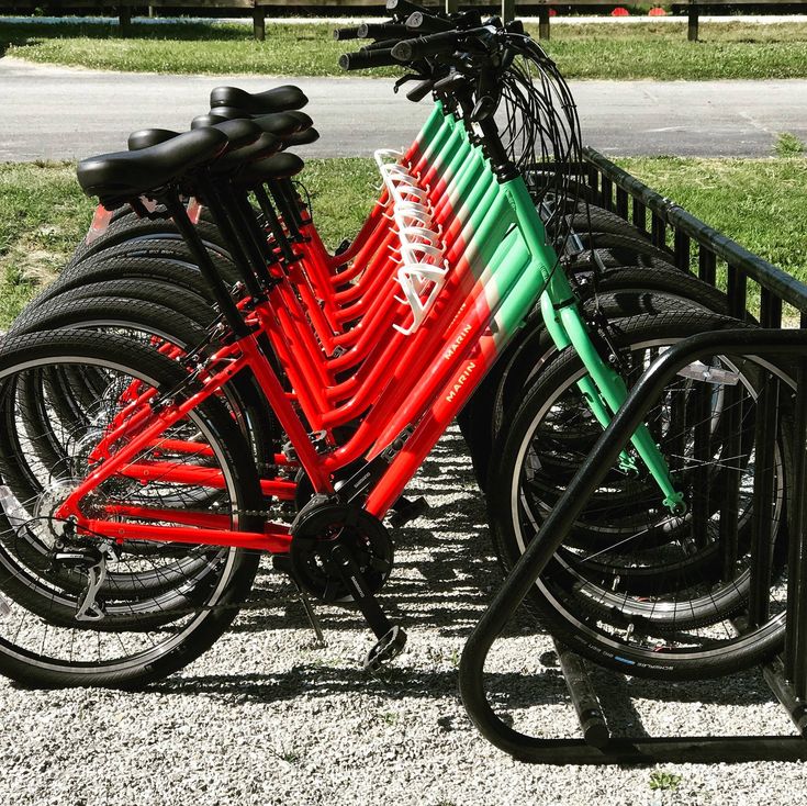 several bicycles are parked next to each other in a row on the side of a road