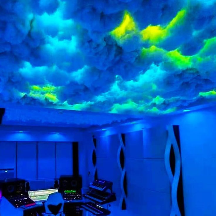 a room with blue lighting and clouds painted on the ceiling above it, as well as sound equipment