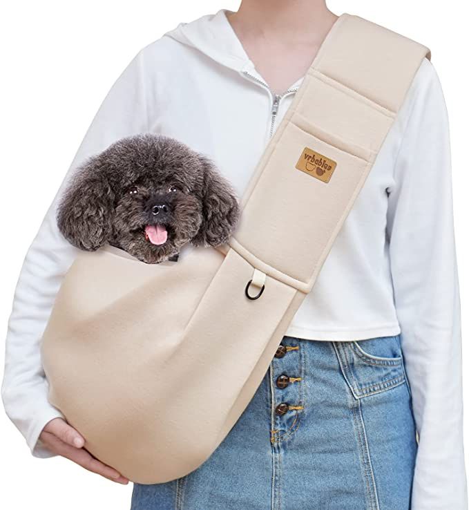 a woman holding a dog in a bag