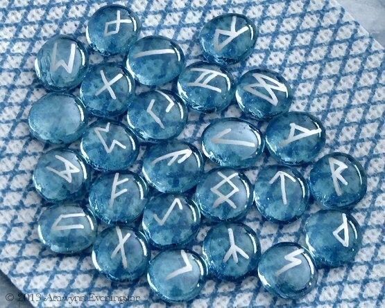 blue glass beads with white letters and numbers on them, sitting on a tablecloth