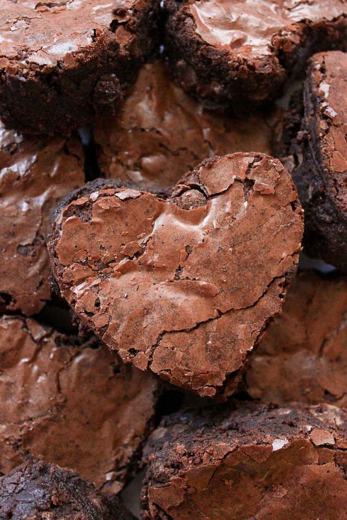 chocolate brownies in the shape of hearts are piled on top of each other,