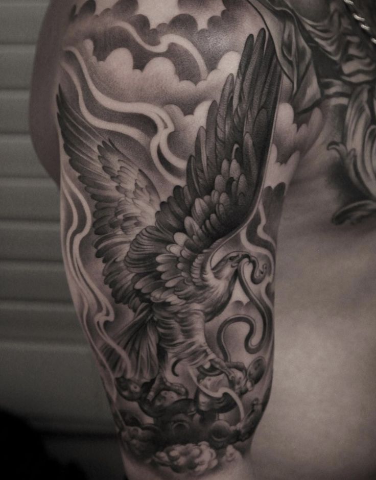 a man's half sleeve with an eagle and clouds tattoo on his left arm