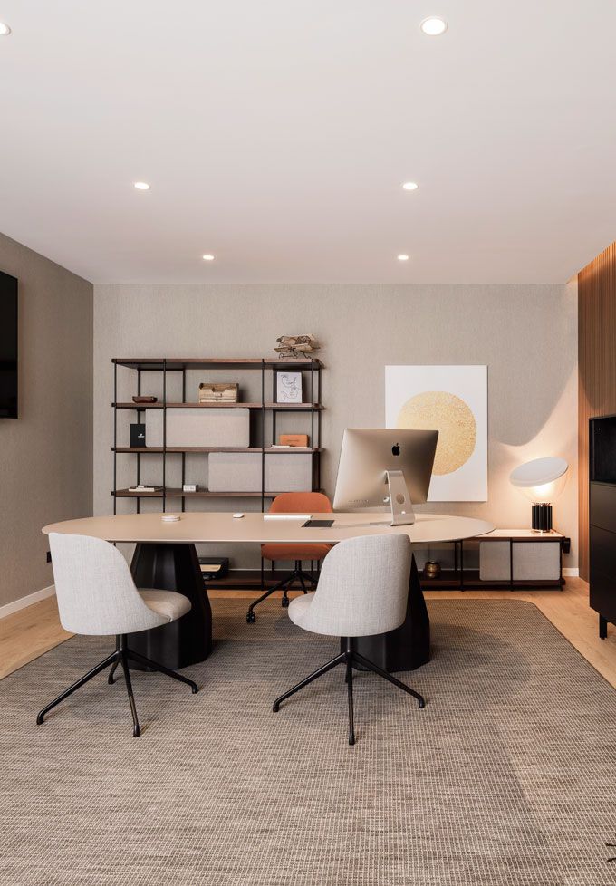 an office with two chairs, a desk and a book shelf in the middle of the room