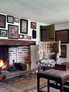 a living room with a fire place and pictures on the wall above it's fireplace