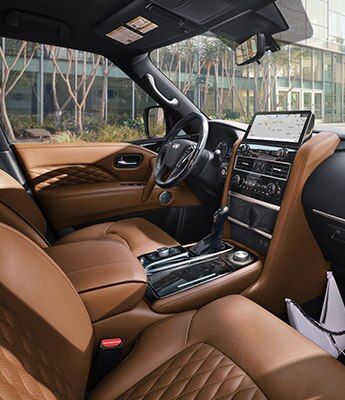 the interior of a modern car with tan leather seats and dashboard, in front of an office building