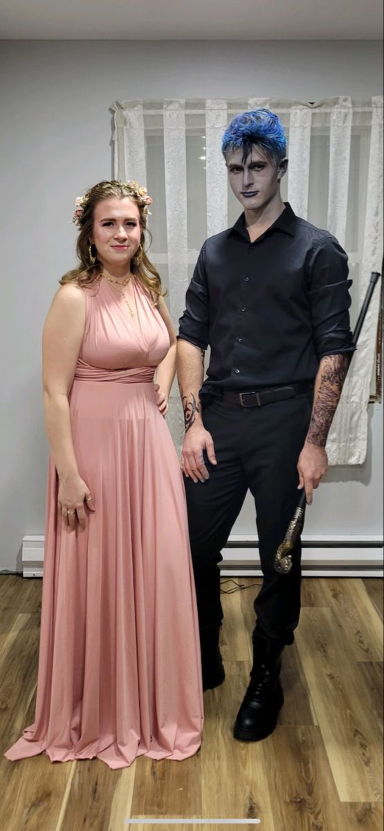 a man and woman in costume standing next to each other on a hard wood floor