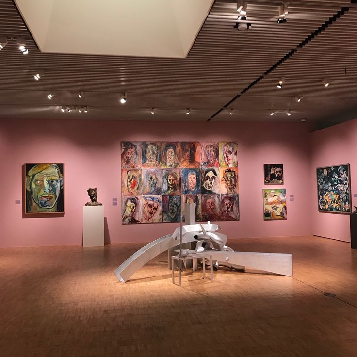 an art gallery with pink walls and paintings on the wall, including a white sculpture