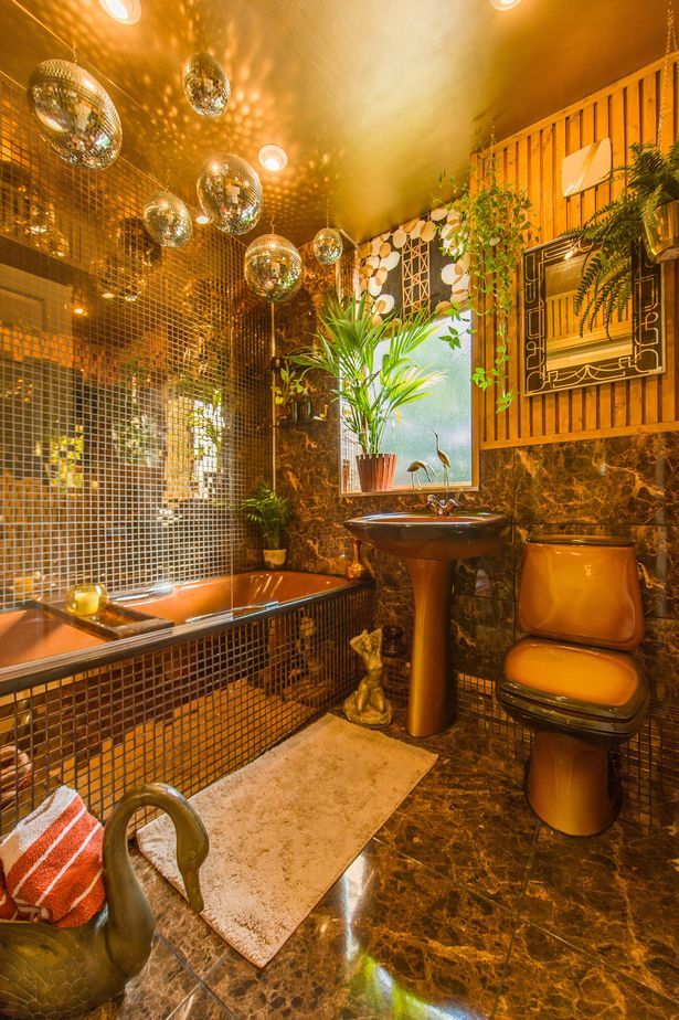 a bath room with a tub a sink and a mirror