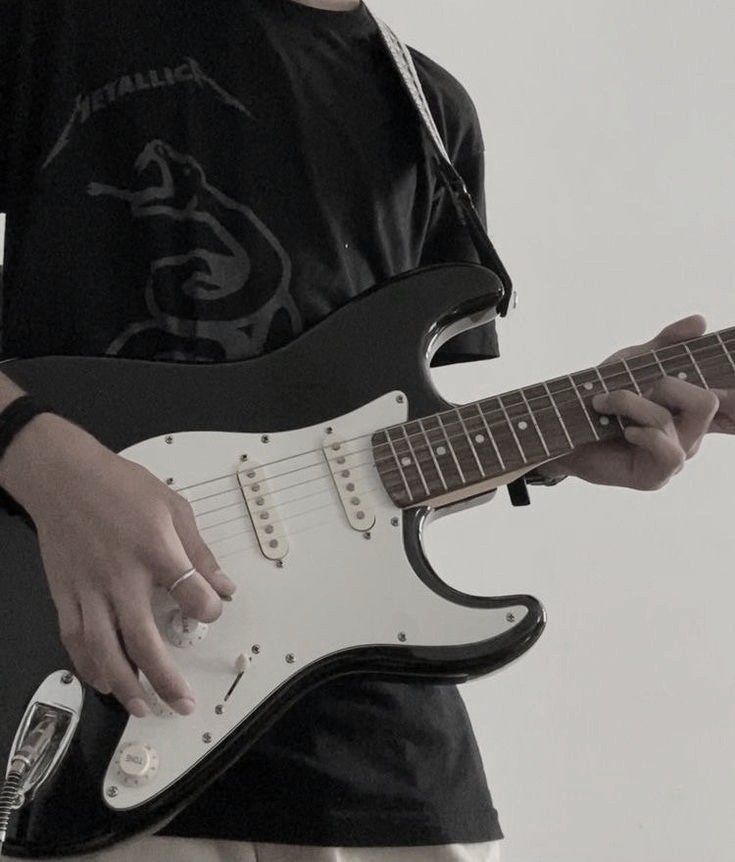 a young boy is playing an electric guitar