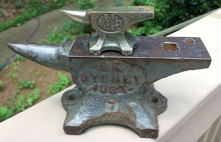 an old metal hammer is sitting on a ledge