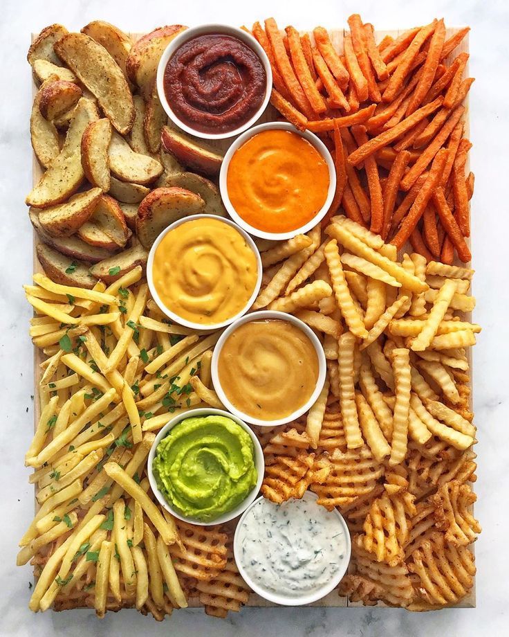 a platter filled with fries, dips and sauces on top of each other