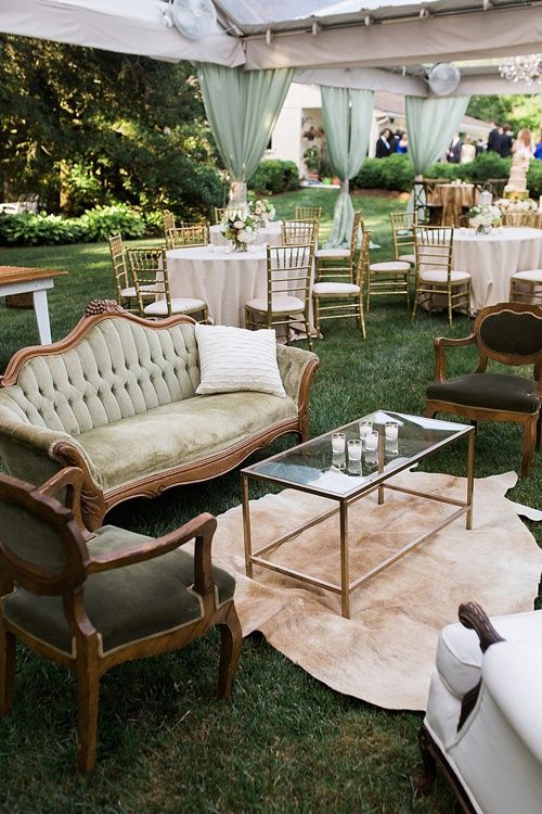 an outdoor seating area with couches, chairs and tables set up in the grass