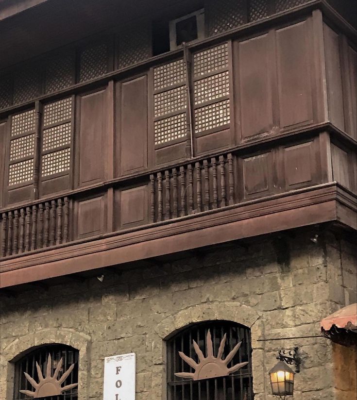 an old building with iron bars on the balconies and wooden railings above it