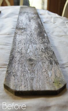 a piece of wood sitting on top of a white table cloth covered dining room table