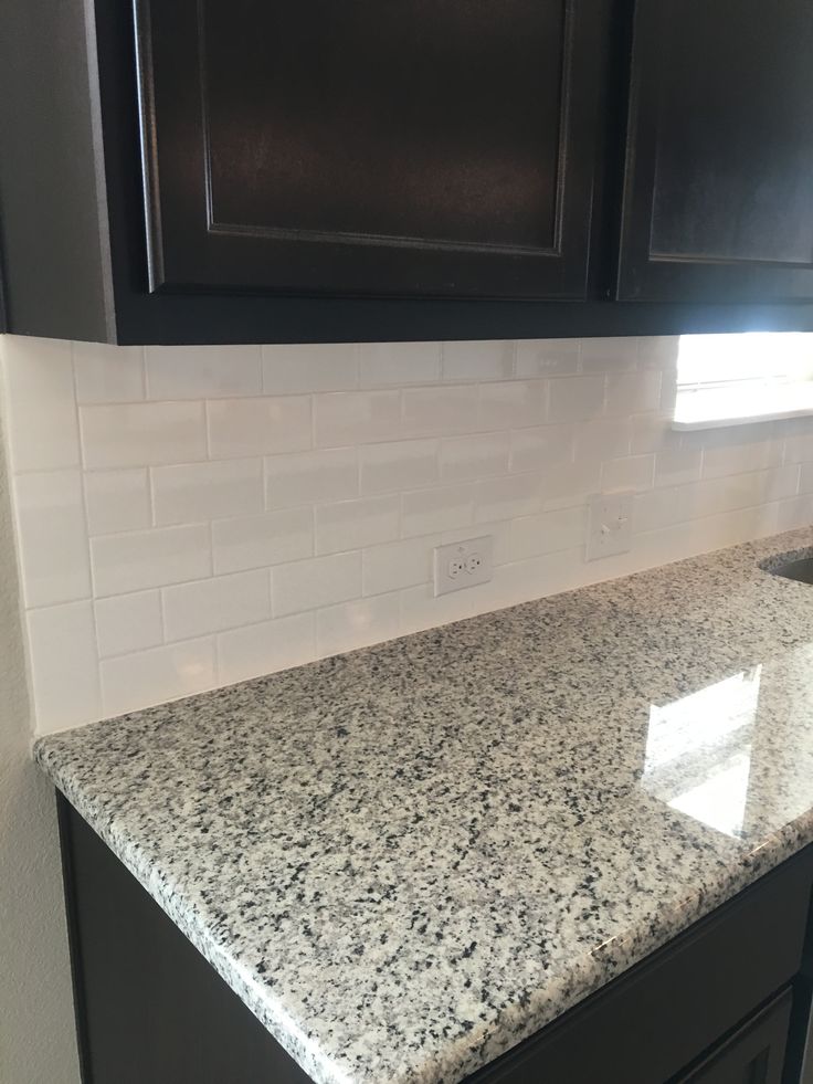 a granite counter top in a kitchen with black cabinets