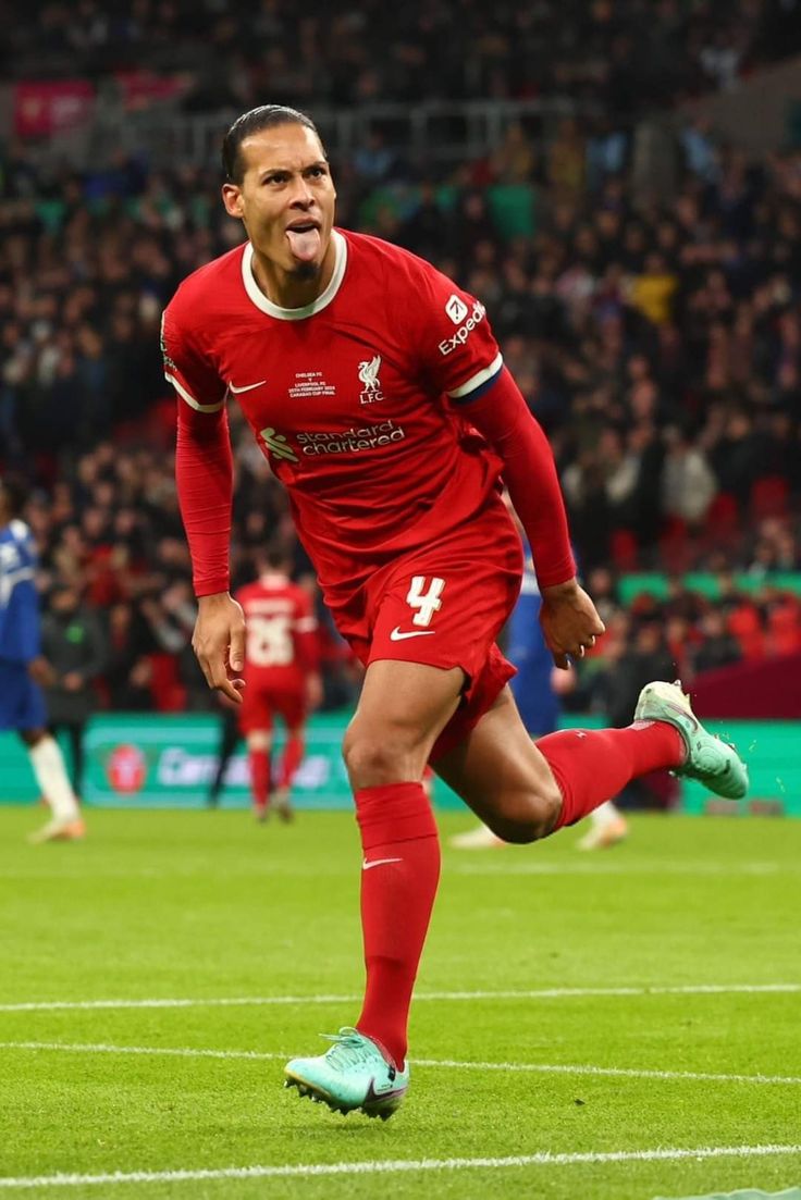 a soccer player is running on the field with his mouth open and eyes wide open