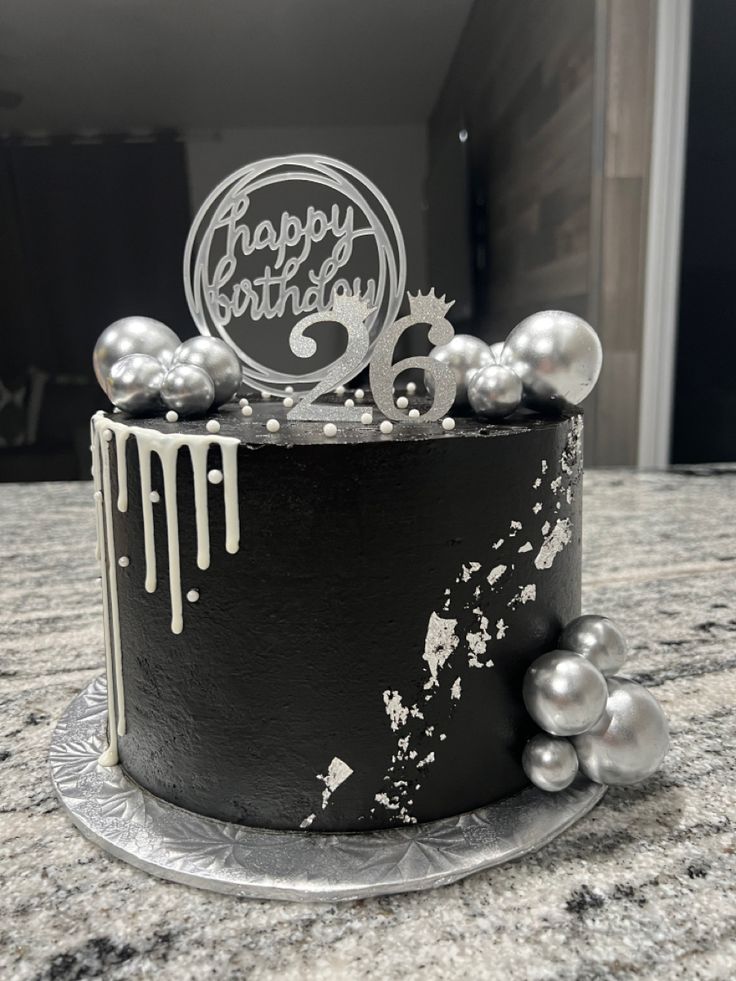 a black and white birthday cake with silver decorations