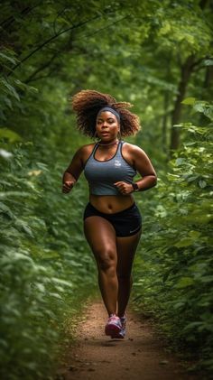 a woman running down a trail in the woods