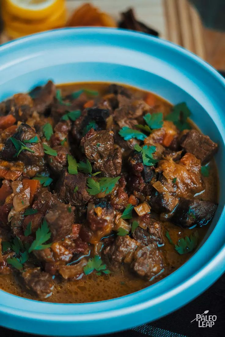 a blue bowl filled with meat and vegetables