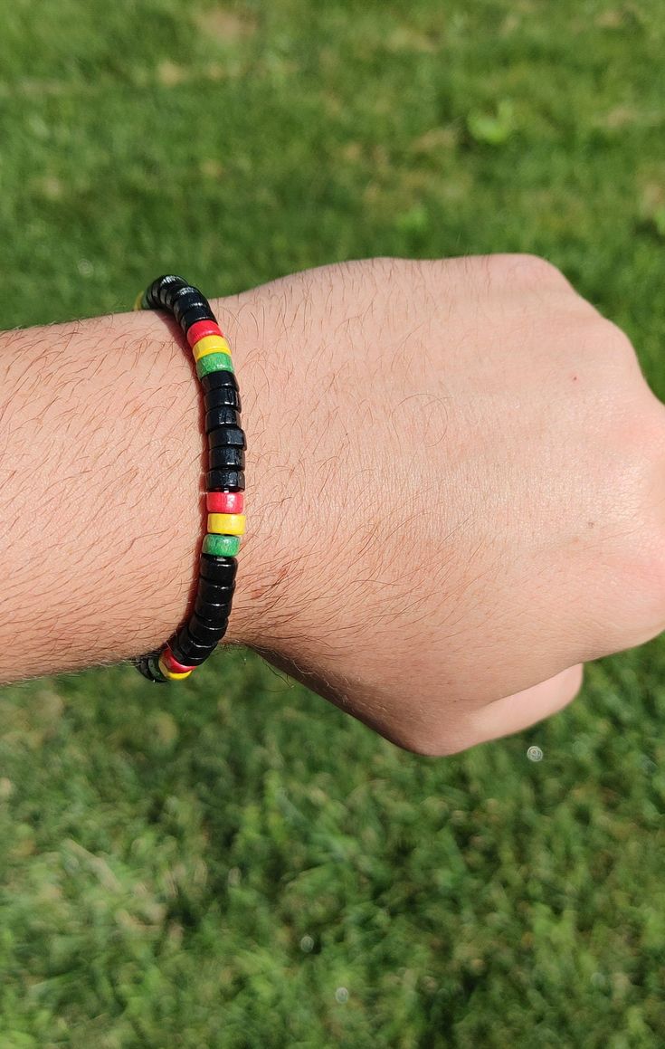 A lively tribute to Rastafarian heritage and style. This bracelet showcases a harmonious blend of red, green, yellow, and black beads, meticulously crafted to embody the spirit of unity and freedom. Each bead is carefully selected and strung on a durable elastic band, ensuring a comfortable fit for any wrist size. Ideal for casual wear, festivals, or as a bold statement piece, this Rasta Bead Bracelet infuses your look with vibrant energy and a touch of bohemian flair. Black Wristband With Colorful Beads Gift, Casual Black Bracelets For Festival, Adjustable Black Friendship Bracelet With Colorful Beads, Traditional Black Adjustable Beaded Bracelets, Casual Black Wristband With Colorful Beads, Adjustable Black Wristband With Colorful Beads, Adjustable Black Beaded Bracelets With Colorful Beads, Black Friendship Bracelets With Colorful Beads As Gift, Multicolor Hand-strung Wristband For Festivals