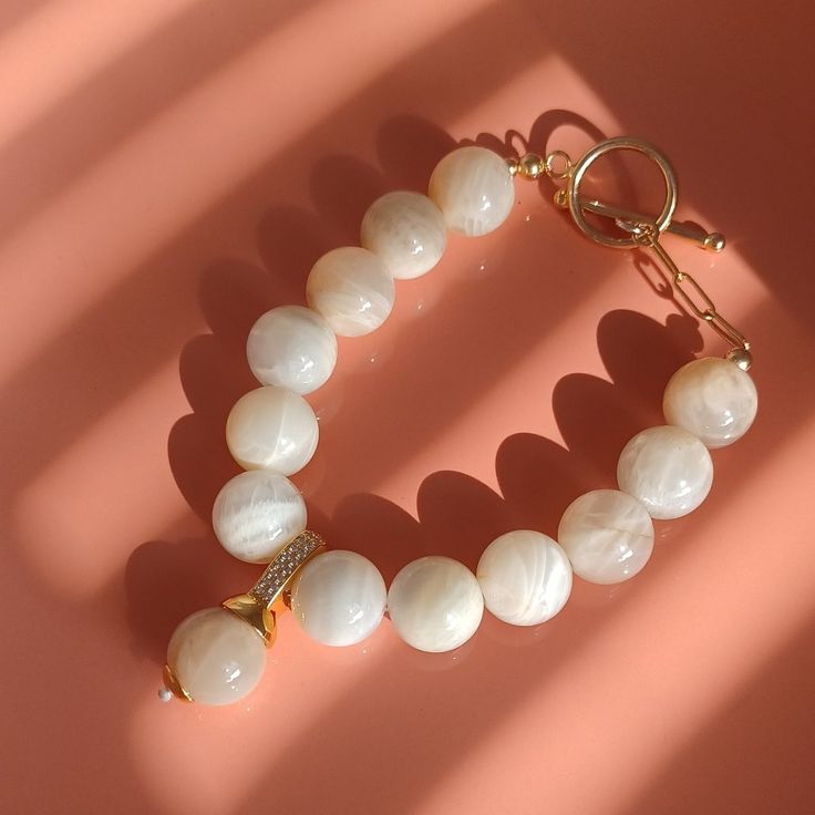 New Product ! All Of Our Gemstones Are Demagnetized With Sea Salt To Keep The Gemstones Pure And Alive! & One Of A Kind, Unique Jewelry ; & 100% Original Design & Handmade & Made In Nyc; Size: 6 - 7" Adjust Size , Fit Most Wrist Sizes. Material: Natural Quality Moonstone 12mm, 14k Yellow Gold Over 925 Sterling Silver With Cz Pendant And 14k Gold Filled. Gold Moonstone Round Bracelets, Elegant Moonstone Gemstone Beaded Bracelets, Elegant Moonstone Beaded Bracelets As Gift, Elegant Moonstone Beaded Bracelet As Gift, Elegant Moonstone Gemstone Bracelets, Elegant Moonstone Crystal Bracelet With Round Beads, Elegant Moonstone Beaded Bracelets, Elegant Moonstone Gemstone Bracelet, White Elegant Crystal Bracelet With Natural Stones