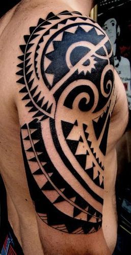 a black and white tattoo on the back of a man's shoulder with an intricate design