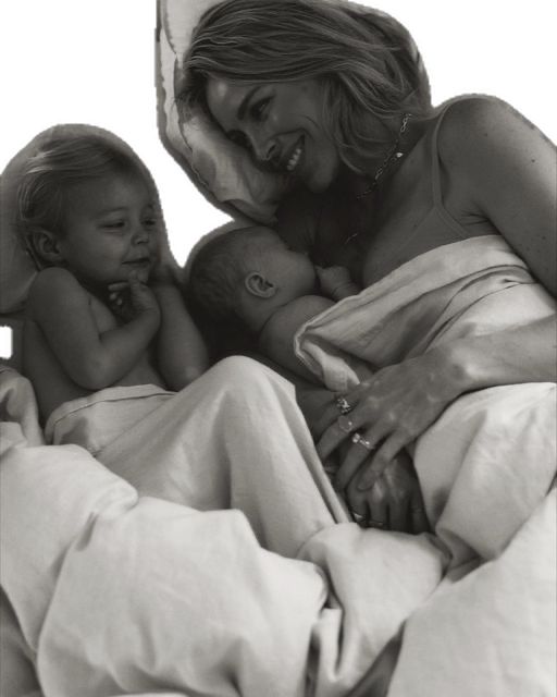 a woman laying in bed with two babies