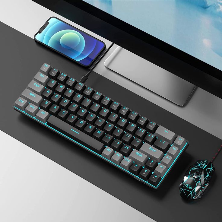 a computer keyboard and mouse sitting next to each other on a desk with a cell phone