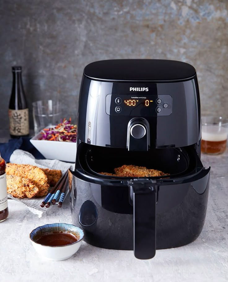 an air fryer with some food in front of it